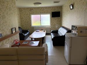 a living room with a couch and a table at Guesthouse Yoichi in Yoichi