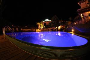a large blue swimming pool at night at Eco Hotel Montemerlo in Fetovaia