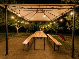 a picnic table with two benches under a tent at Heaven Retreat in Vusanje
