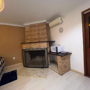 a living room with a fireplace and a microwave at Quarto Suíte Master Luxo in Santana do Livramento