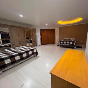 a living room with two beds and a yellow ceiling at Quarto Suíte Master Luxo in Santana do Livramento +7 photos