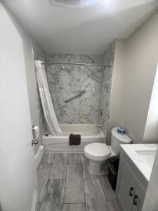 a bathroom with a tub and a toilet and a sink at Nites Inn Motel in Cornwall