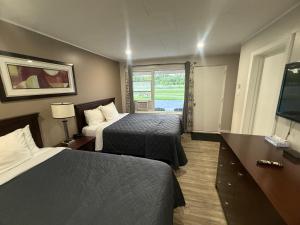 a hotel room with two beds and a window at Nites Inn Motel in Cornwall