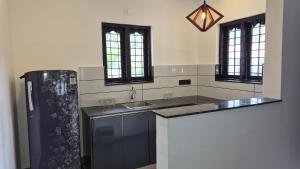 a kitchen with a sink and a refrigerator at Casa Luminaria in Alleppey