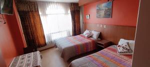 a hotel room with two beds and a window at Pacha Confort in Puno