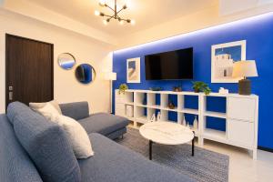 a blue living room with a couch and a tv at West Press Sasebo in Sasebo