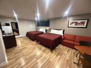 a hotel room with two beds and a couch at Nites Inn Motel in Cornwall