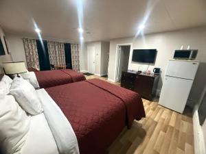 a hotel room with two beds and a flat screen tv at Nites Inn Motel in Cornwall +30 photos