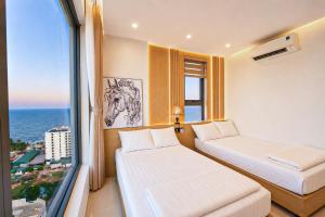 a hotel room with two beds and a window at The Pathway Condotel in Sầm Sơn +29 photos