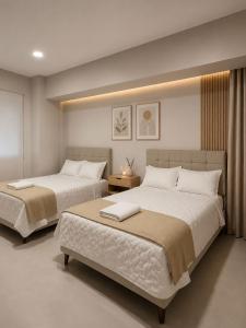 two beds in a hotel room with at Centrica Suite Hotel in Huarmey