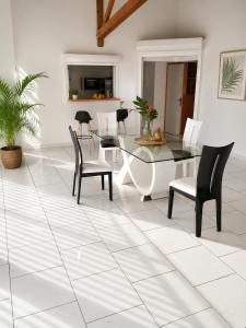 a dining room with a glass table and chairs at Kaz an Fanmi in Les Abymes +18 photos