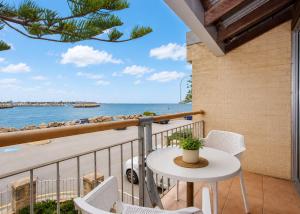 a balcony with a table and chairs and the ocean at Mariners Lookout Absolute Harbour Views in Fremantle