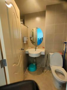 a bathroom with a toilet and a sink and a mirror at wongwian N in Ban Bo Khaem