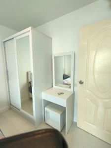a white bathroom with a mirror and a white table at wongwian N in Ban Bo Khaem