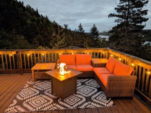 a patio with a table and chairs on a deck at Finnegan's Cottage in Placentia