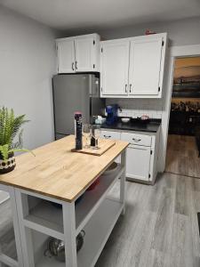 a kitchen with white cabinets and a wooden counter top at Cozy One Bedoom apartment in Saint John +17 photos