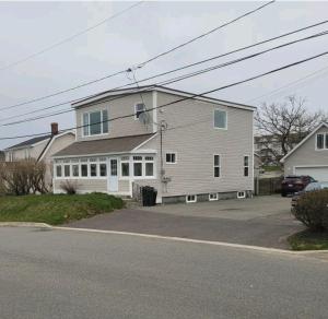 a large house with a car parked in front of it at Cozy One Bedoom apartment in Saint John