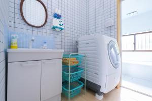 a bathroom with a sink and a washing machine at サウナ&ステイ吉日荘-益子町のプライベートサウナ付の貸切古民家 BBQ 高速Wi-fi in Mashiko