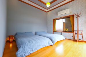 a bedroom with two beds and a window at サウナ&ステイ吉日荘-益子町のプライベートサウナ付の貸切古民家 BBQ 高速Wi-fi in Mashiko +59 photos