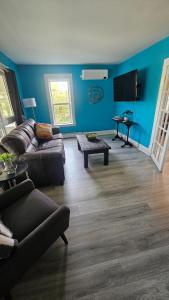 a living room with blue walls and a couch and a table at Cozy One Bedoom apartment in Saint John
