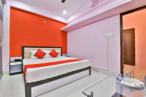 a bedroom with a bed with an orange wall at Hotel O Magadh Imperial in Patna