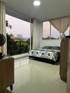 a bedroom with a bed and a large window at El Chaparral in Yopal
