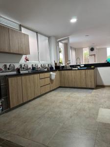 a large kitchen with wooden cabinets and a tile floor at El Chaparral in Yopal