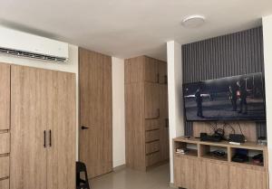 a living room with wooden cabinets and a flat screen tv at El Chaparral in Yopal