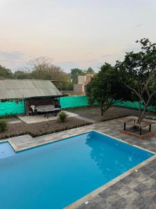 a blue swimming pool in front of a house at El Chaparral in Yopal