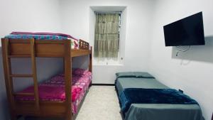 a bedroom with a bunk bed and a tv at Casa Largo Katayama in Ruiosucio