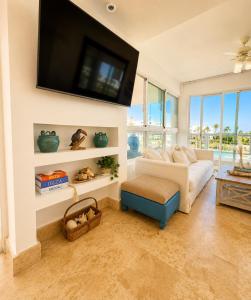 a living room with a couch and a flat screen tv at Beachfront Luxury Condo PGA Ocean View 4BR in Boca del Soco +56 photos