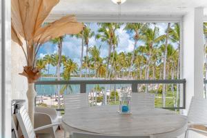 a dining room with a table and chairs and palm trees at Beachfront Luxury Condo PGA Ocean View 4BR in Boca del Soco
