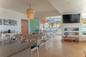a kitchen and dining room with tables and chairs at Beachfront Luxury Condo PGA Ocean View 4BR in Boca del Soco
