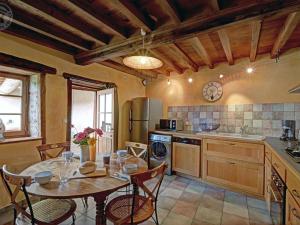 a kitchen with a table and some chairs and a table and a kitchen with at Gîte de charme rénové 3 épis, 2 chambres en pleine nature - FR-1-496-92 in Palogneux
