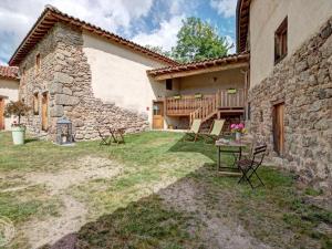 an external view of a house with chairs and a table at Gîte de charme rénové 3 épis, 2 chambres en pleine nature - FR-1-496-92 in Palogneux