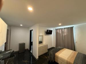 a bedroom with a bed and a tv on the wall at Apartamento Maywood in Zacatecas