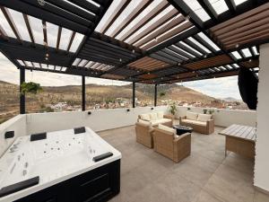 a patio with a hot tub and couches and windows at Apartamento Maywood in Zacatecas