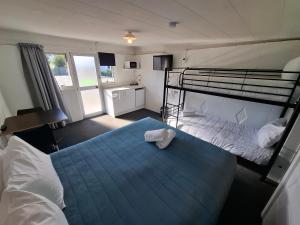 a bedroom with two bunk beds and a blue bed at Spring Creek Holiday Park in Blenheim