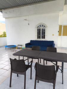 a table and chairs in a room with a blue couch at Paraiso Suite Centrico con entrada independiente in Paraíso