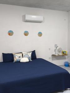 a bed with blue sheets and pillows in a bedroom at Paraiso Suite Centrico con entrada independiente in Paraíso