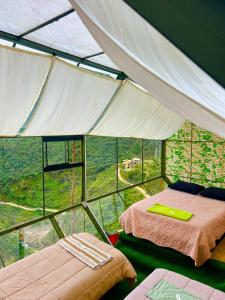 a room with two beds in a tent at Hanging Nest Salkantay in Colcapampa