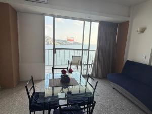 a living room with a glass table and a blue couch at Bonita Suite Torres Gemelas in Acapulco