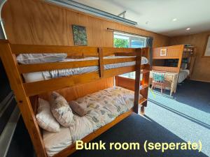 a bunk room with two bunk beds in it at Banana Bungalow Studio in Raglan +1 photo