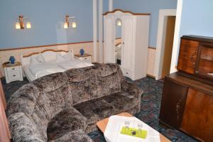 ein Wohnzimmer mit einem Sofa und einem Bett in der Unterkunft Hotel Central in Bad Elster