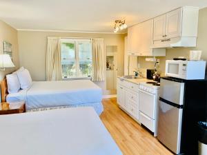 a hotel room with two beds and a kitchen at The Chatham Motel in Chatham