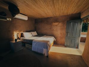 a bedroom with a bed and an open door at Lahara - Komari in Ampara