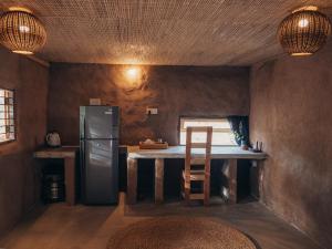 a small kitchen with a table and a refrigerator at Lahara - Komari in Ampara