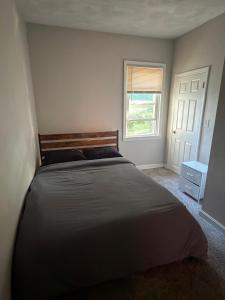 a bedroom with a large bed and a window at Providence Cozy Stays in Providence