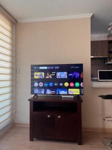 a flat screen tv on a wall in a room at Departamento Los Poetas in Temuco