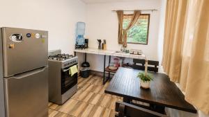 a small kitchen with a table and a refrigerator at Aloha Popoyo in Playa Santana +38 photos